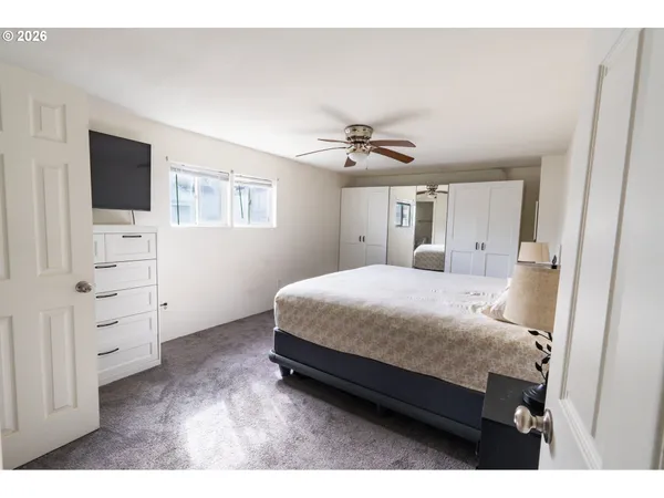 a bedroom with a bed and tv on the wall
