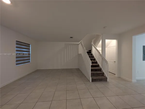 an empty room with stairs and white walls