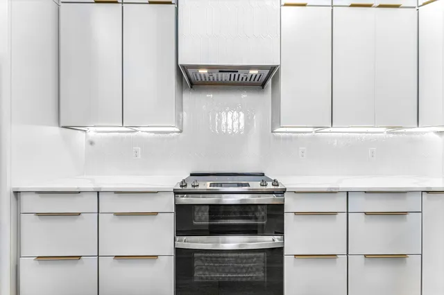 a kitchen with granite countertop a stove and a microwave