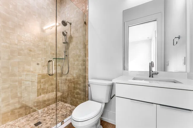 a bathroom with a sink a toilet and shower