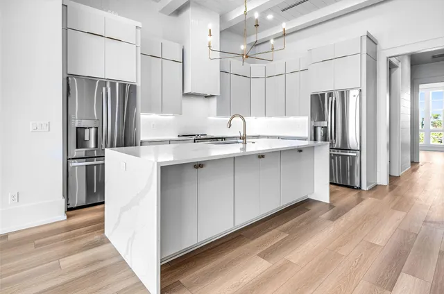 a kitchen with stainless steel appliances a refrigerator sink and microwave