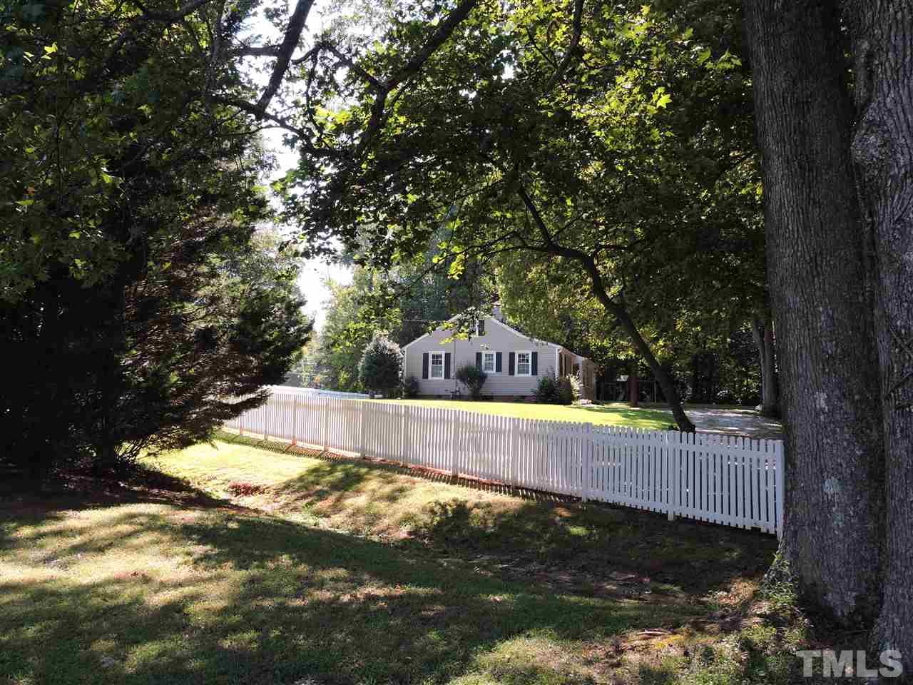 10819 North Roxboro Road Rougemont, NC 27572 - Photo 4 of 19 a view of a back yard with a large tree and a small yard