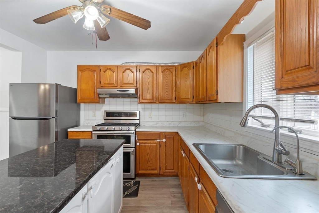 524 Merrimack Street Methuen, MA 01844 - Photo 11 of 42 a kitchen with stainless steel appliances granite countertop a sink a stove and a refrigerator