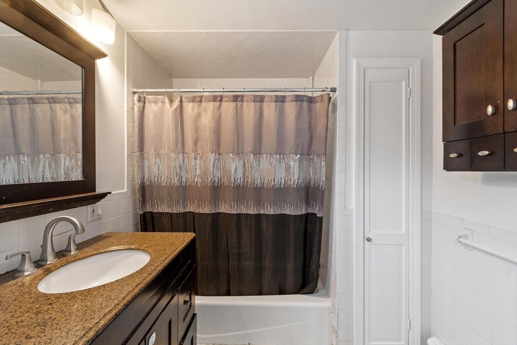 524 Merrimack Street Methuen, MA 01844 - Photo 17 of 42 a bathroom with a granite countertop sink and a mirror