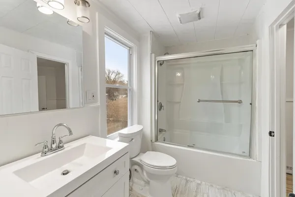 a bathroom with a sink toilet a mirror and shower