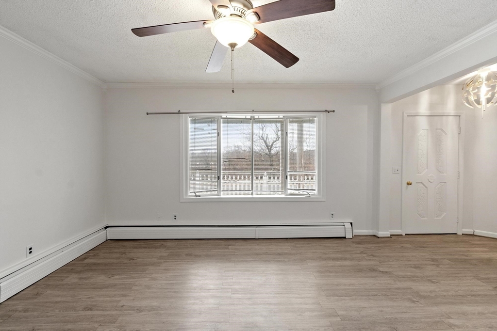 524 Merrimack Street Methuen, MA 01844 - Photo 3 of 42 an empty room with wooden floor chandelier fan and windows