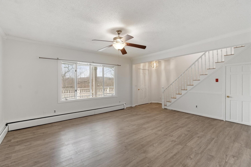 524 Merrimack Street Methuen, MA 01844 - Photo 5 of 42 an empty room with wooden floor chandelier fan and windows