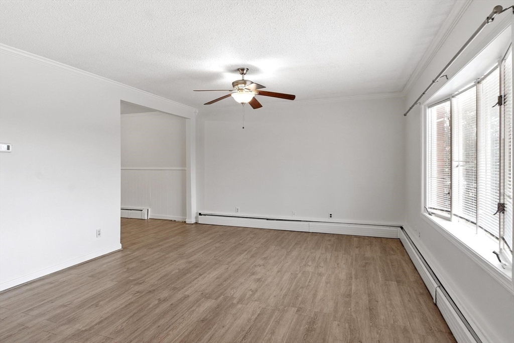 524 Merrimack Street Methuen, MA 01844 - Photo 6 of 42 an empty room with wooden floor ceiling fan and windows