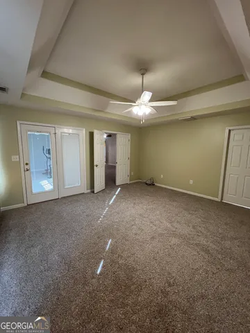 a view of an empty room with a chandelier fan