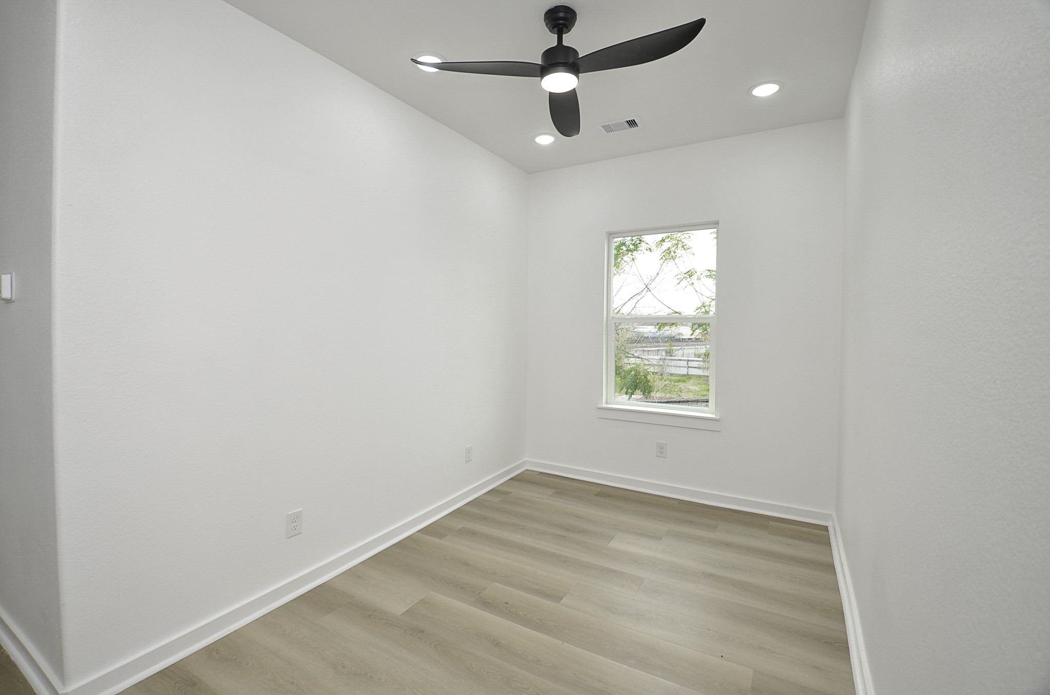 9312 Waller Street Houston, TX 77012 - Photo 11 of 26 an empty room with a window and a ceiling fan