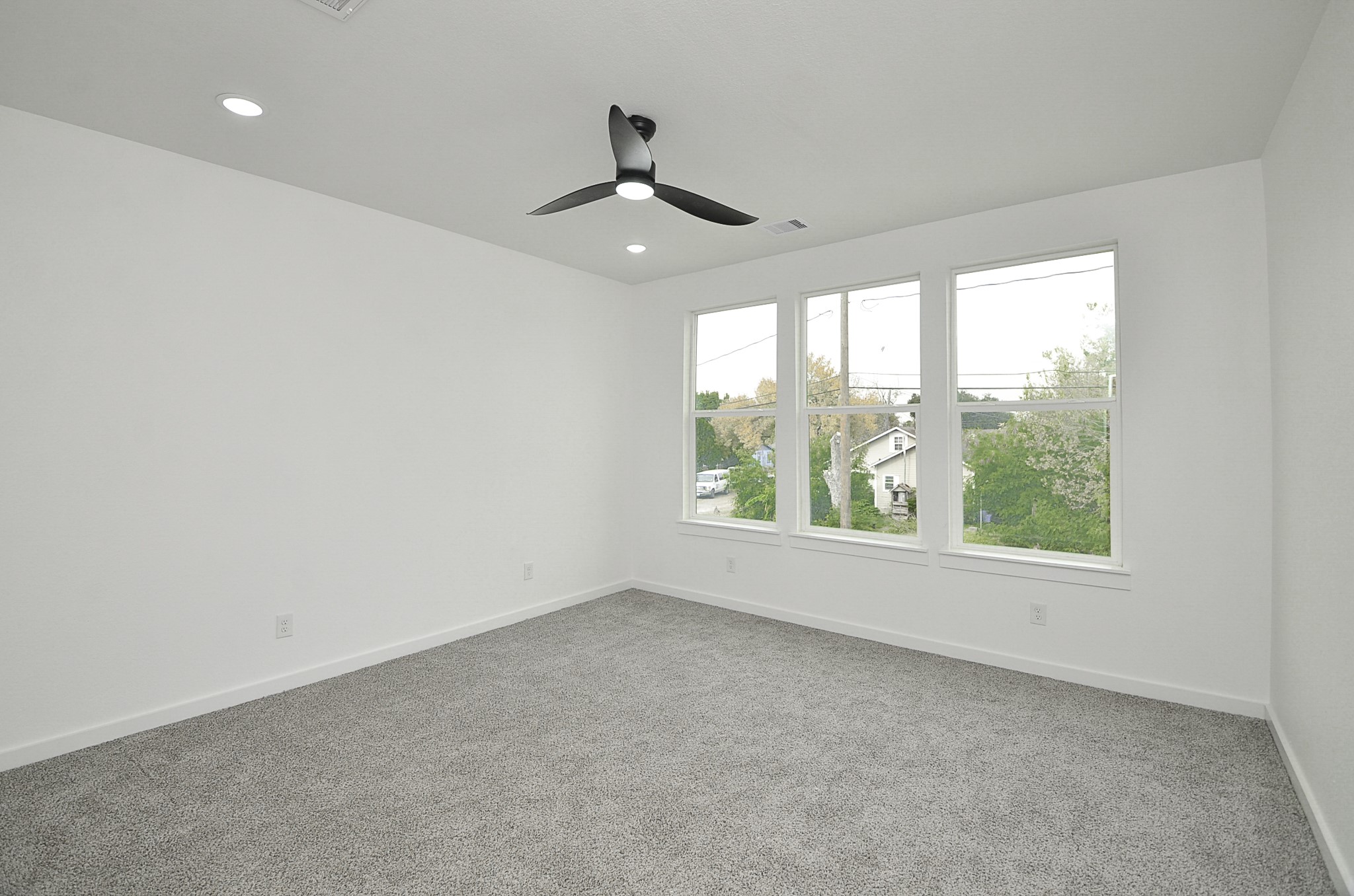 9312 Waller Street Houston, TX 77012 - Photo 16 of 26 an empty room with windows and ceiling fan