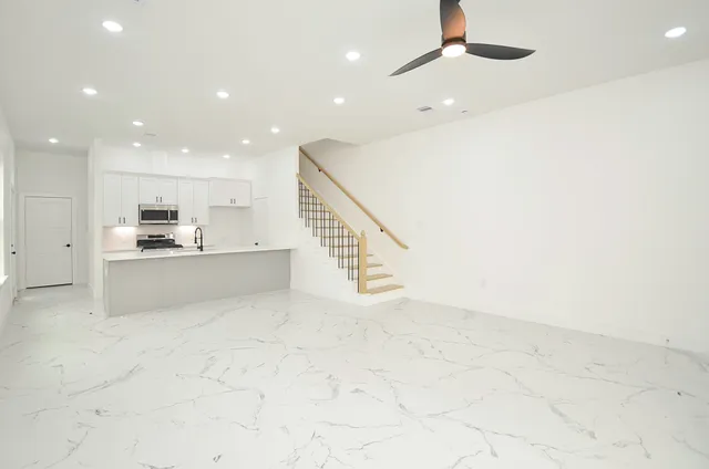 a view of kitchen with kitchen island microwave and cabinets
