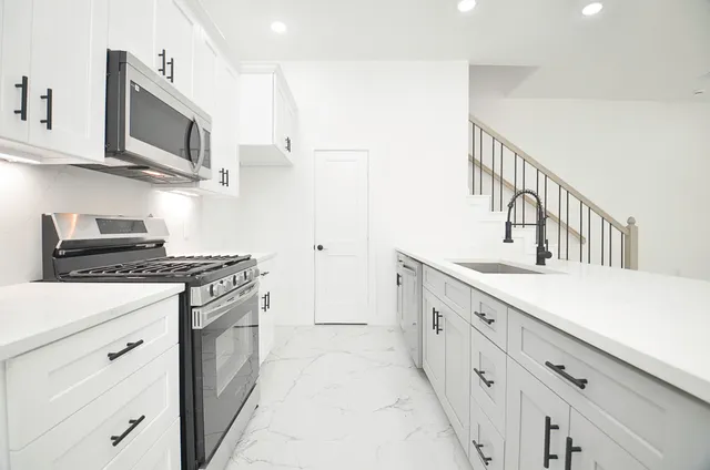 a kitchen with stainless steel appliances a stove microwave and cabinets