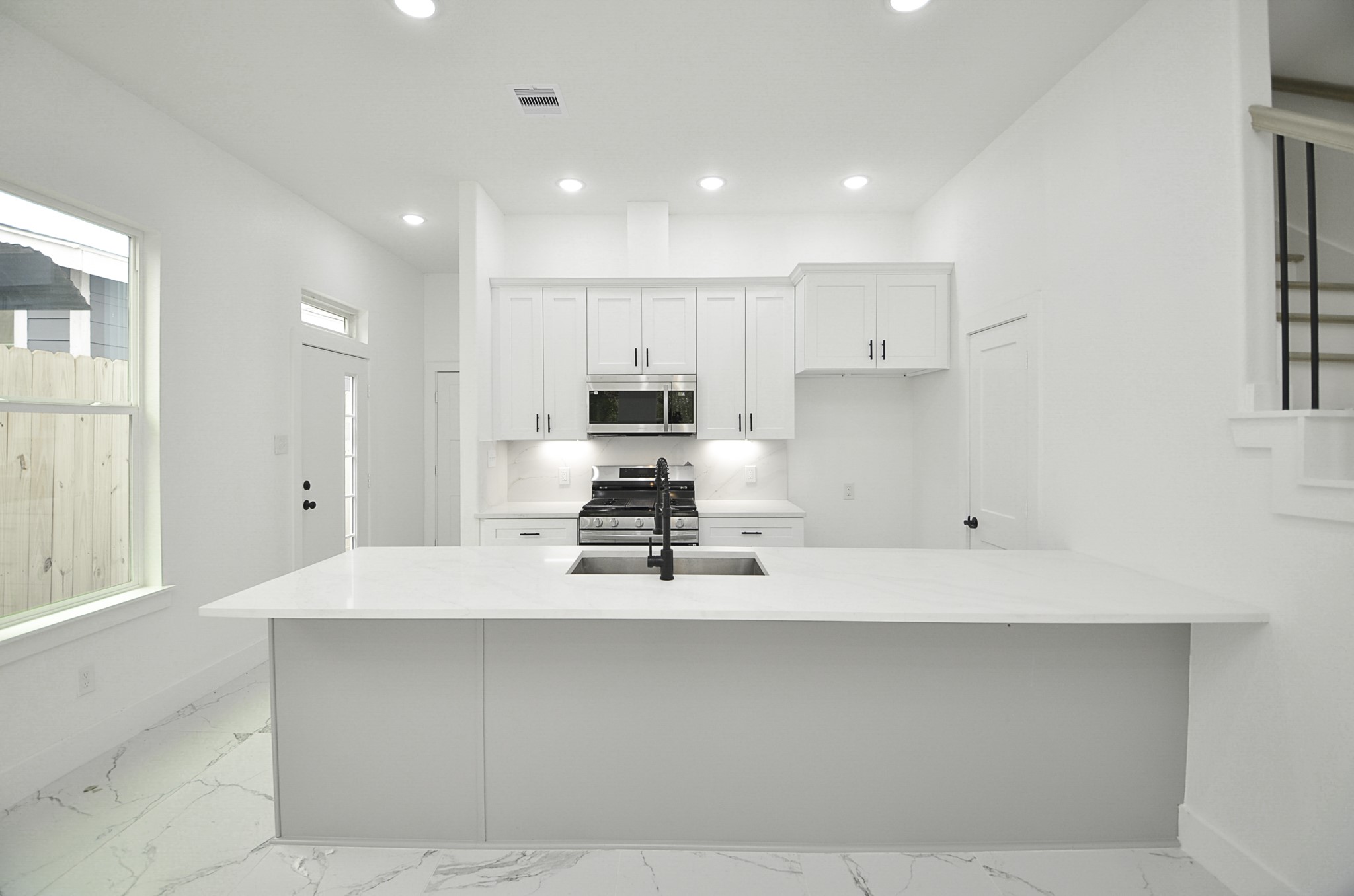 9312 Waller Street Houston, TX 77012 - Photo 8 of 26 a kitchen with kitchen island white cabinets and stainless steel appliances