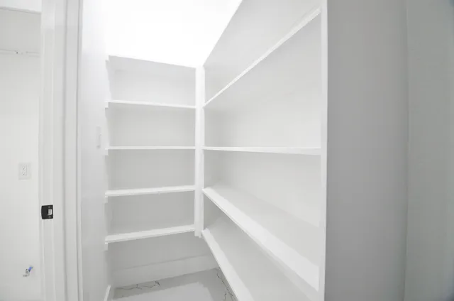 a view of walk in closet with empty racks