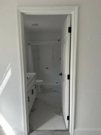 a bathroom with a granite countertop sink and shower