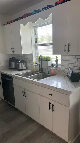 a kitchen with sink a window and cabinets