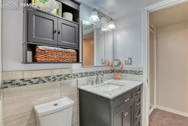 a bathroom with a sink a toilet and mirror