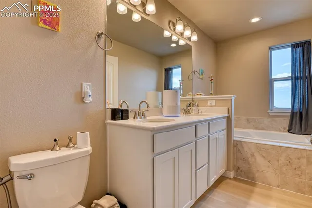 a bathroom with a granite countertop bathtub shower sink mirror and toilet