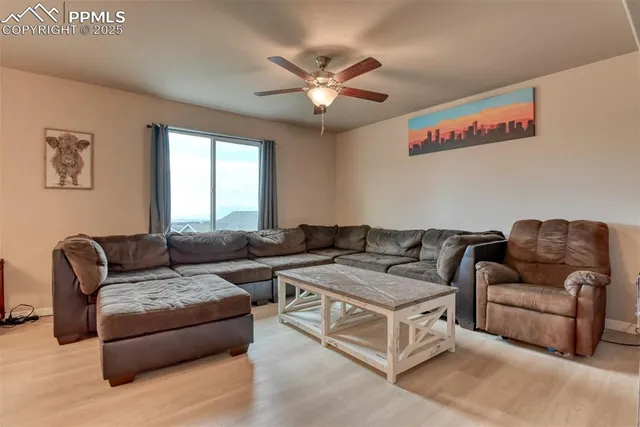 a living room with furniture and a ceiling fan