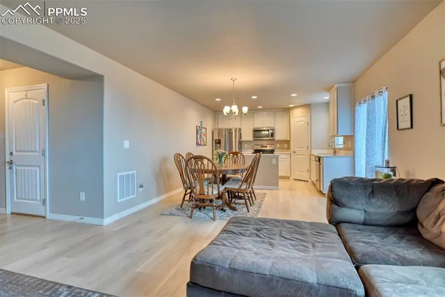 a living room with furniture and kitchen view