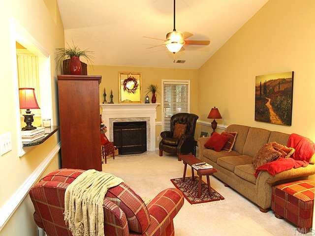 8705 Walkelin Court Raleigh, NC 27615 - Photo 2 of 12 The large family room has vaulted ceilings, ceiling fan, and a gas fireplace.