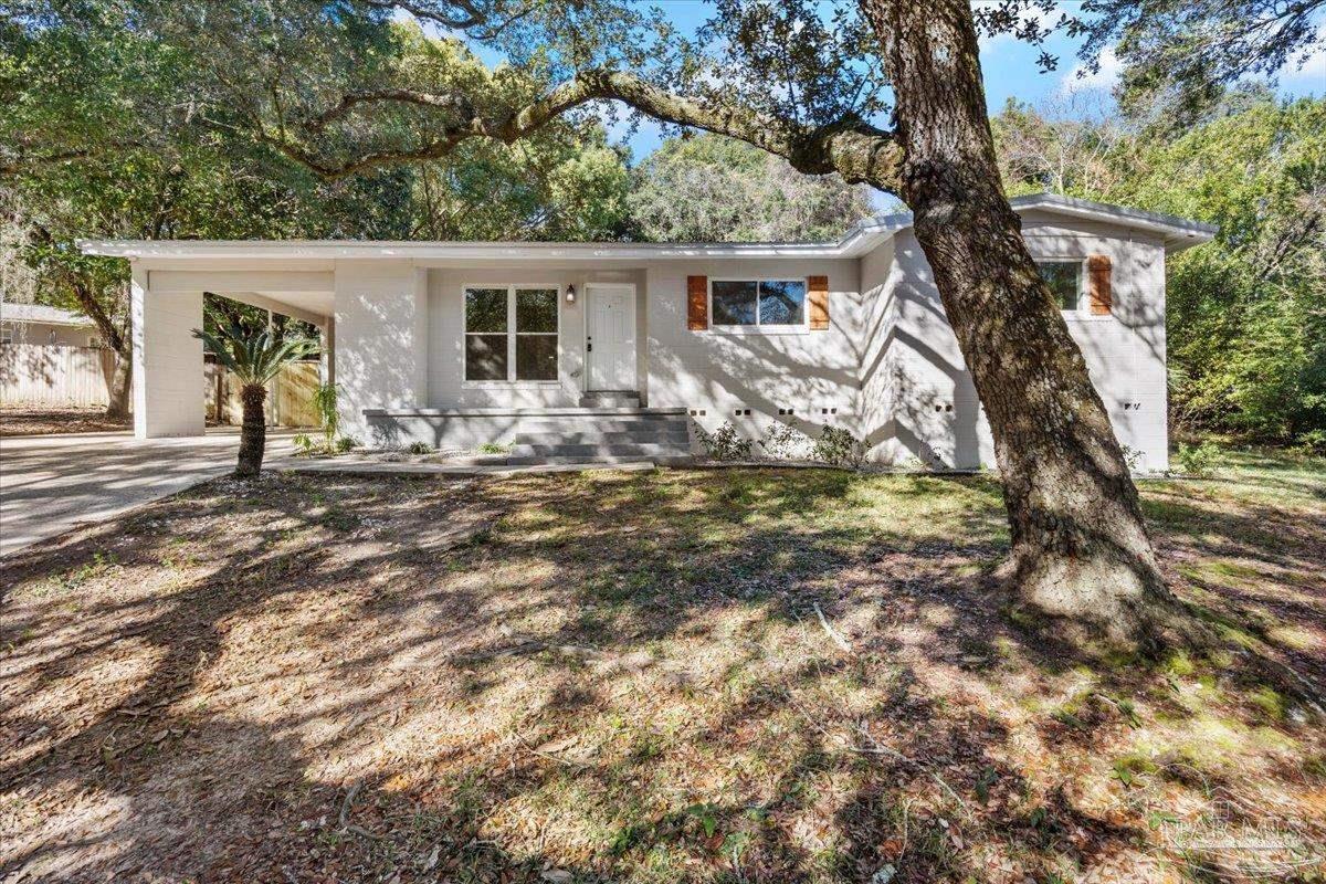 5149 Crestwood Road Pensacola, FL 32503 - Photo 1 of 53 a front view of a house with garden