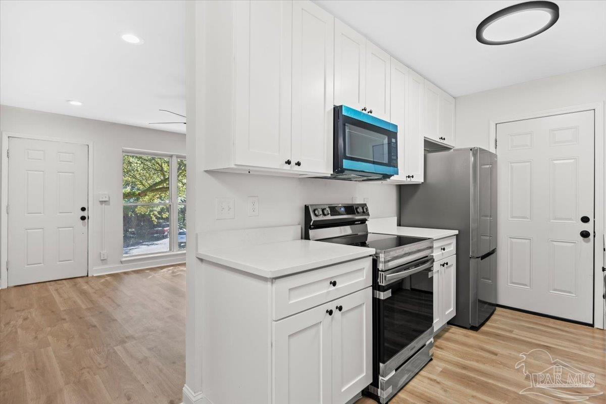 5149 Crestwood Road Pensacola, FL 32503 - Photo 11 of 53 a kitchen with stainless steel appliances a stove microwave and refrigerator