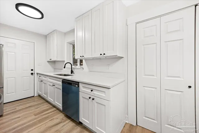 a kitchen with white cabinets and sink