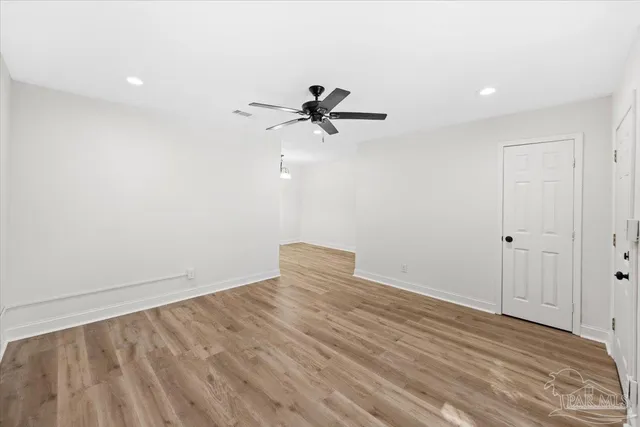 a view of a room with wooden floor and a ceiling fan