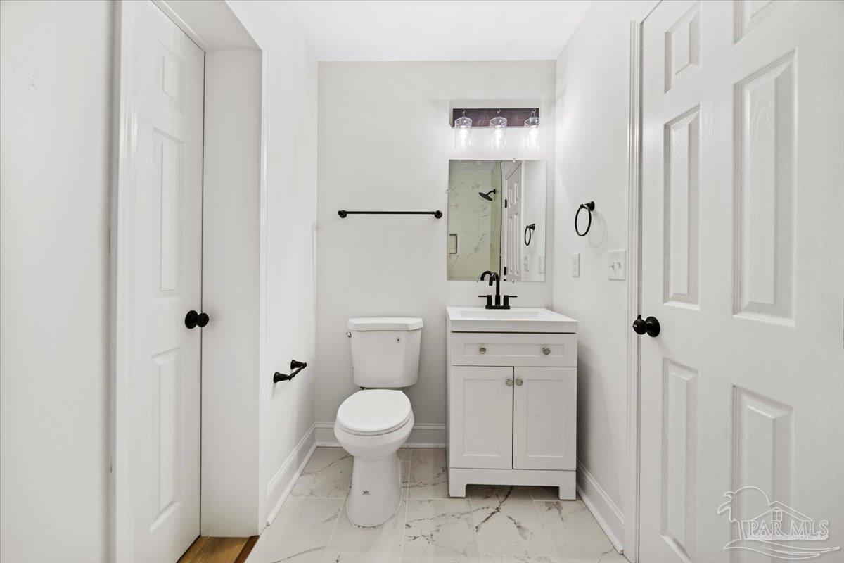 5149 Crestwood Road Pensacola, FL 32503 - Photo 19 of 53 a bathroom with a toilet a sink a mirror and vanity