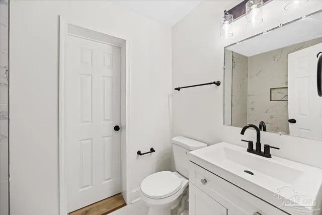 a bathroom with a sink a toilet and a mirror