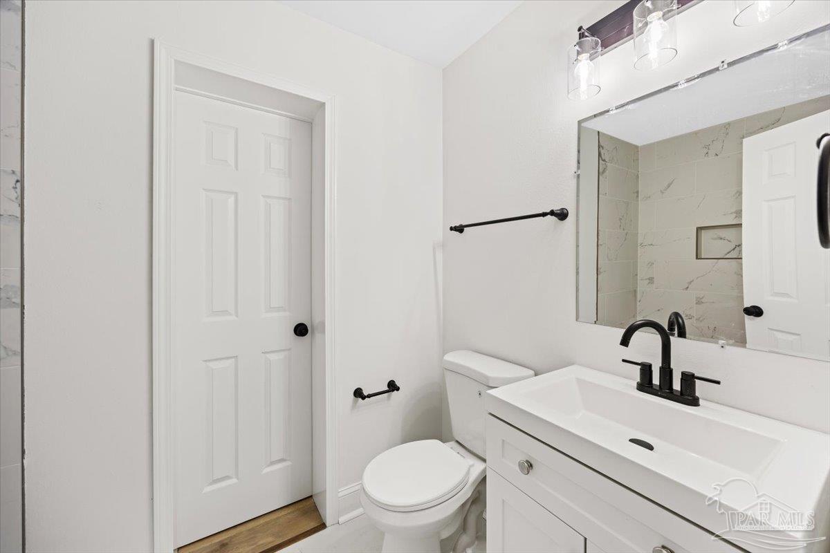 5149 Crestwood Road Pensacola, FL 32503 - Photo 27 of 53 a bathroom with a sink a toilet and a mirror