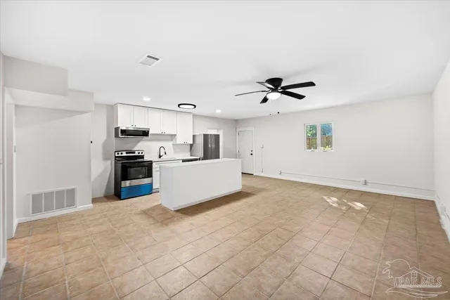 a view of kitchen with cabinets microwave and stove top oven