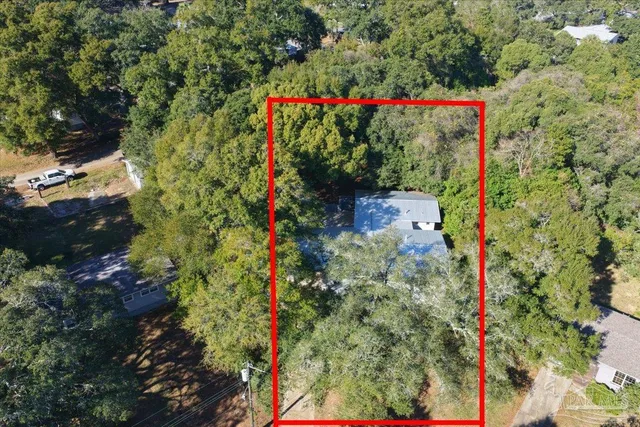 a front view of a house with yard tree and wooden fence