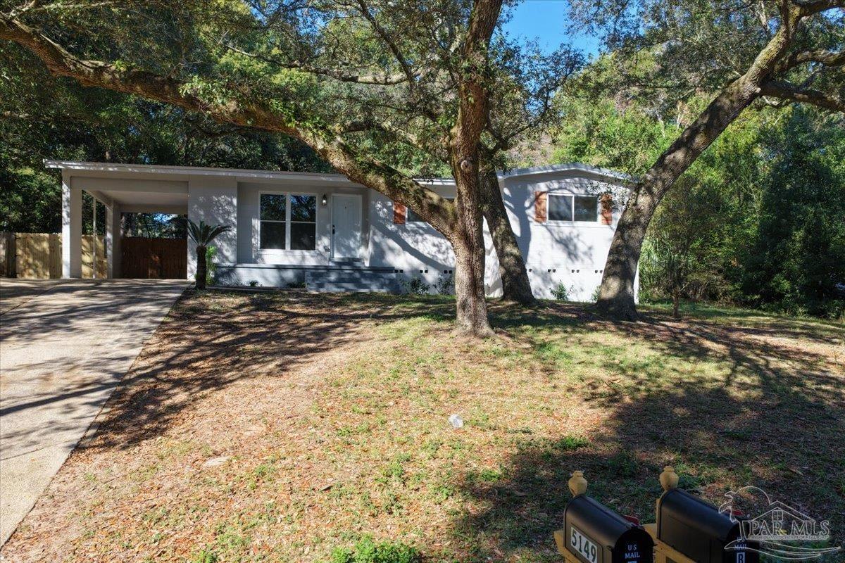 5149 Crestwood Road Pensacola, FL 32503 - Photo 47 of 53 a front view of a house with yard tree and wooden fence