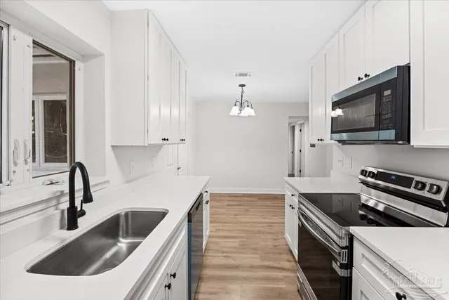 a kitchen with a sink stove and microwave