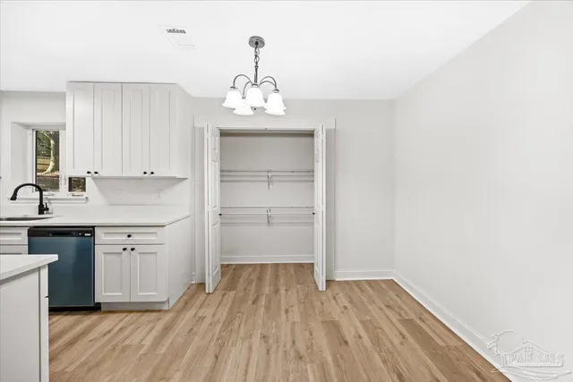 a kitchen with a refrigerator and white cabinets