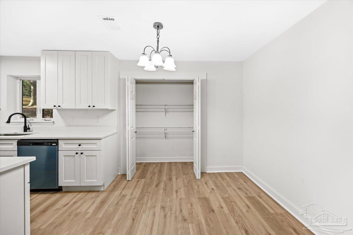 5149 Crestwood Road Pensacola, FL 32503 - Photo 10 of 53 a kitchen with a refrigerator and white cabinets