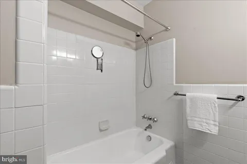 a bedroom with a bed a mirror on dresser and a chandelier