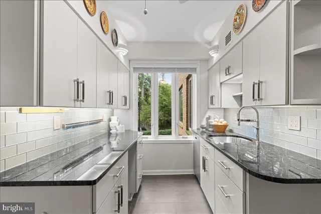 a kitchen with stainless steel appliances granite countertop a refrigerator a stove and a sink