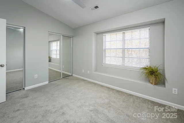 an empty room with windows and closet