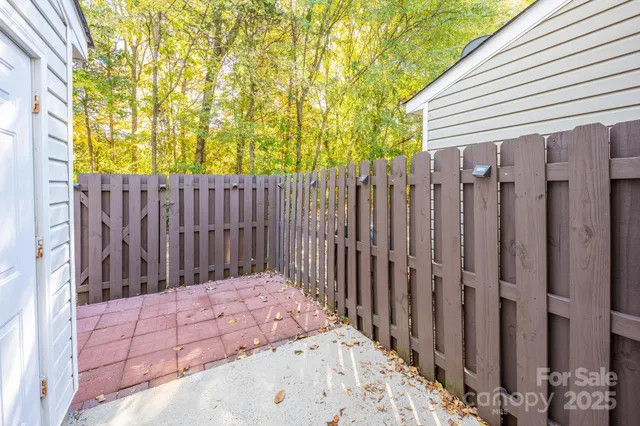 a wooden fence covered with tall trees