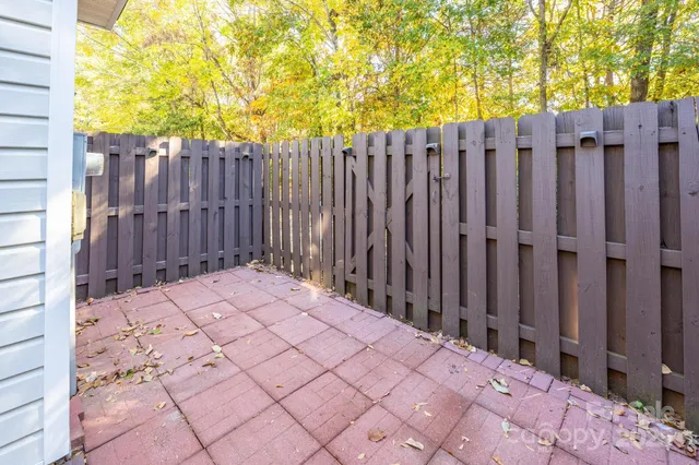 a view of a house with backyard and wooden fence