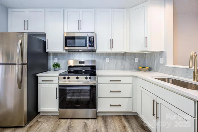 a kitchen with white cabinets and stainless steel appliances
