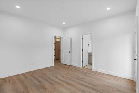 a view of an empty room with wooden floor