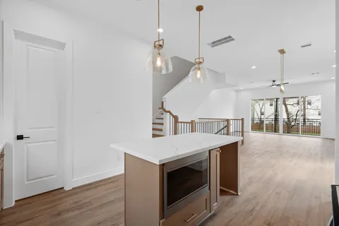 a kitchen with a stove a sink and wooden floor