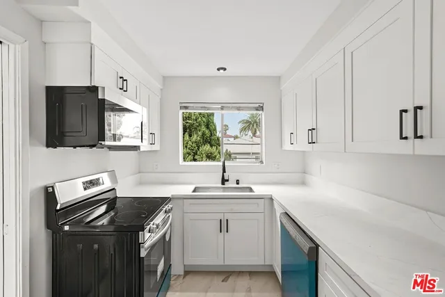 a kitchen with a sink stove top oven and refrigerator