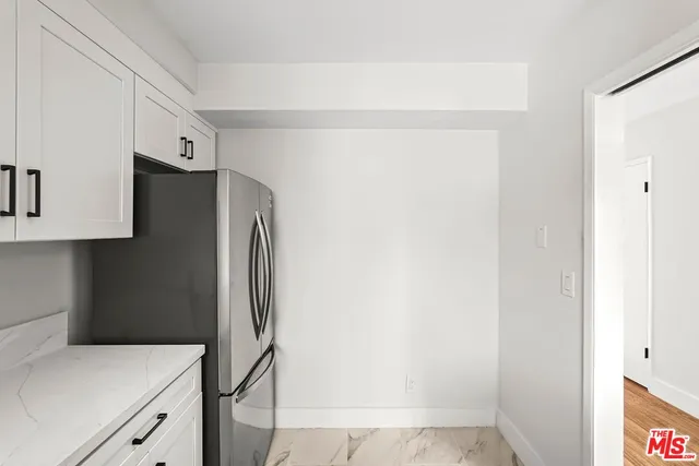 a kitchen with a refrigerator and cabinets