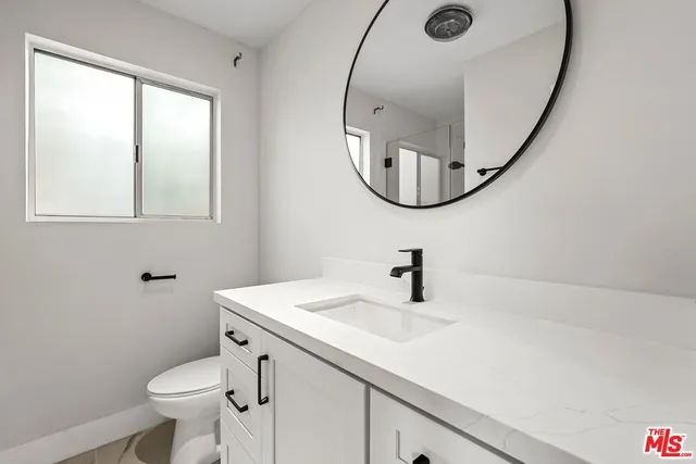 a bathroom with a sink mirror and toilet